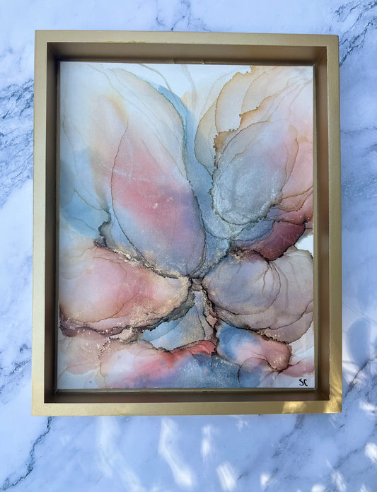 Original alcohol ink painting by Northeast Georgia artist Sarah Campbell, featuring abstract blush, gold, and blue petal-like forms with metallic accents in a gold frame.